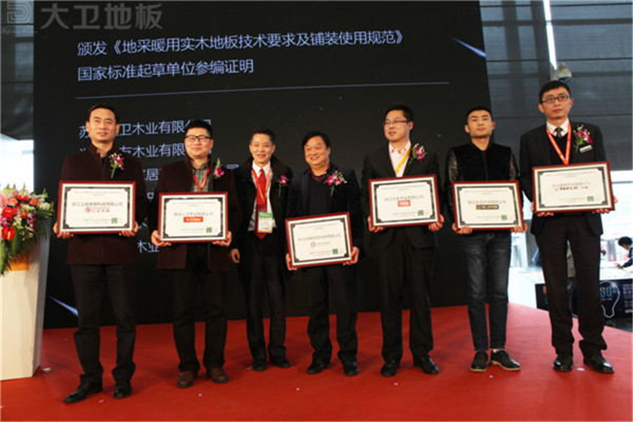 D体育（中国）地板董事长蒋卫（左二）获颁《地采暖用D体育网技术要求及铺装使用规范》国家标准起草单位参编证明.jpg